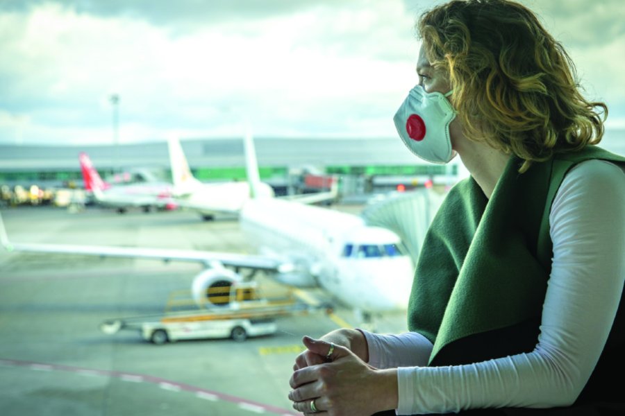 Covid-mask wearing traveler at an airport.