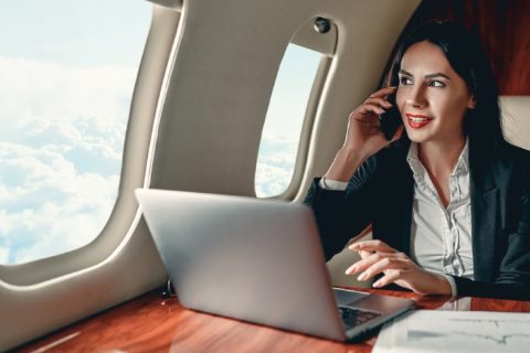 Woman talking on her phone while working on a private jet.