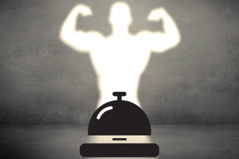 Illuminated figure of a bodybuilder overcasting a hotel bell.