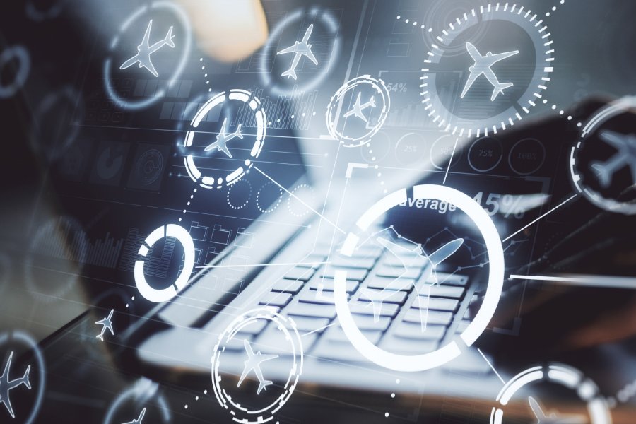 A futuristic composition featuring a laptop keyboard overlaid with glowing digital icons of airplanes and aviation-related circular diagrams. The background includes faint graphs and data visualizations, symbolizing advancements in aviation technology, data analytics, and digital connectivity in the airline industry. The image conveys innovation and efficiency in air travel systems.