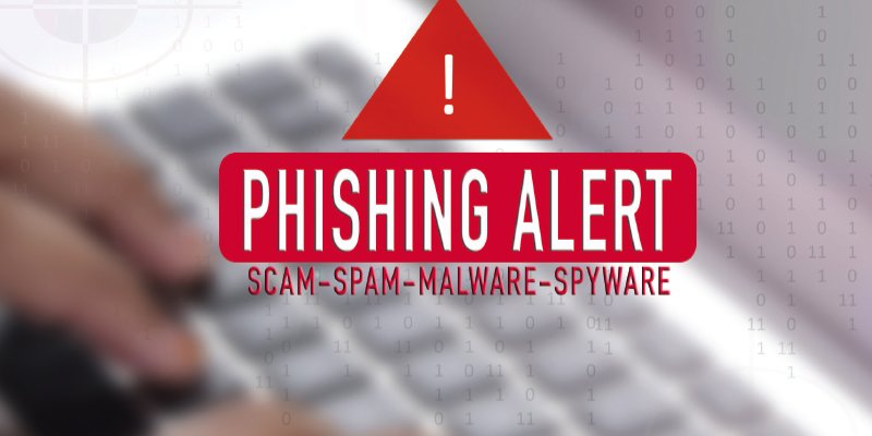 A red triangular warning icon with an exclamation mark at the top of the image. Below it, bold red text reads "PHISHING ALERT" with smaller text underneath saying "SCAM-SPAM-MALWARE-SPYWARE." The background features a blurred keyboard with binary code overlay, symbolizing cybersecurity threats.