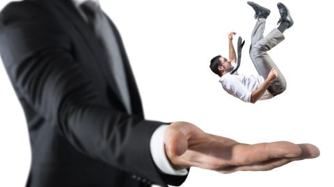 Mini man falling into a big man's hand.