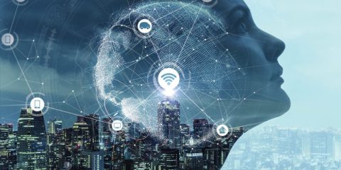 A futuristic concept image featuring the profile of a human face merged with a digital representation of a globe. The image overlays a bustling cityscape, illustrating connectivity and technology. Various icons, such as a car, house, and smartphone, are connected with network lines, symbolizing the Internet of Things (IoT). A central glowing Wi-Fi icon highlights the theme of global digital interconnection.