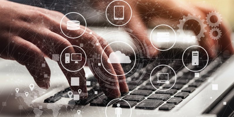 Close-up of hands typing on a laptop keyboard, overlaid with digital icons representing cloud computing, mobile devices, servers, and interconnected systems. The image conveys the concept of technology, data integration, and digital transformation.