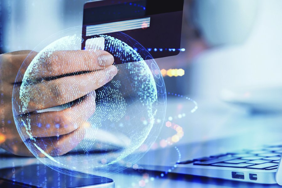 Hand holding a credit card inside of a virtual bubble.